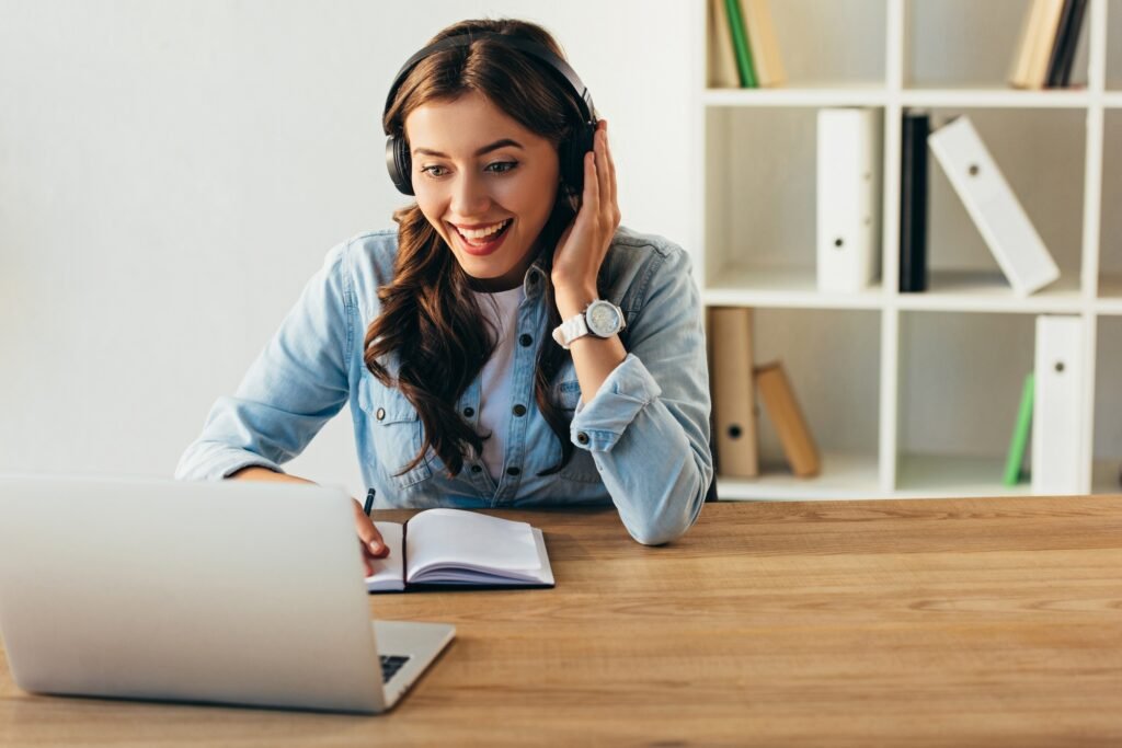 portrait of smiling woman in headphones taking part in webinar in office